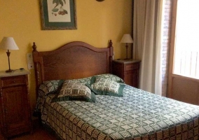  Double bedroom with wooden headboards and plaid blankets 