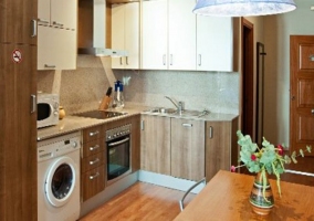  Kitchen with wooden table and washing machine under the hob 