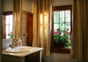 Bathroom with curtains and flowers on the outside 